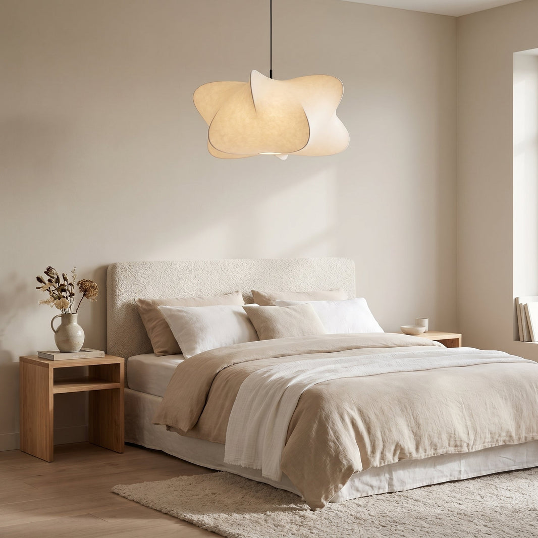 Suspension nuage en soie allumée au plafond d'une chambre claire, au-dessus d'un grand lit en lin beige