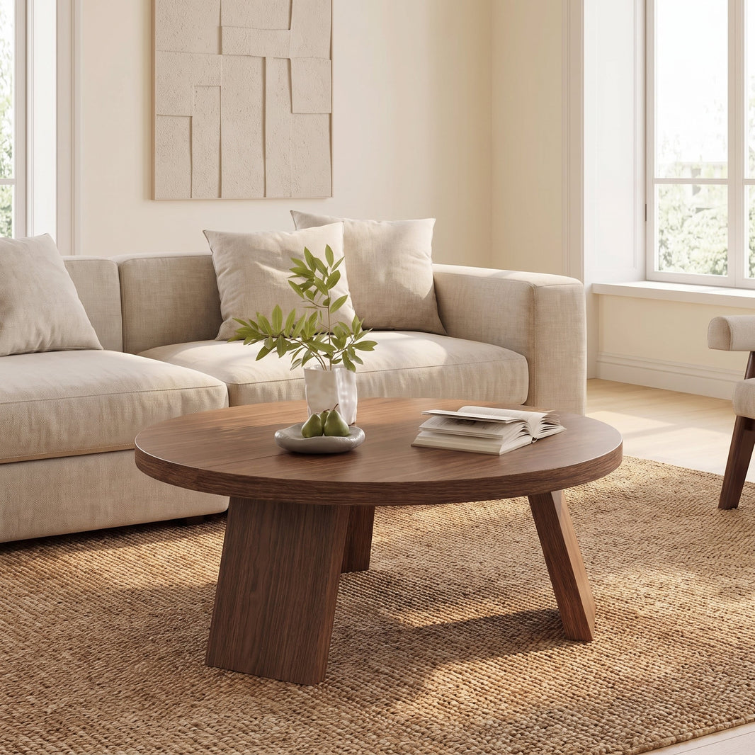 Table basse ronde effet noyer à pieds inclinés devant un canapé beige, sur un tapis en jute dans un salon clair