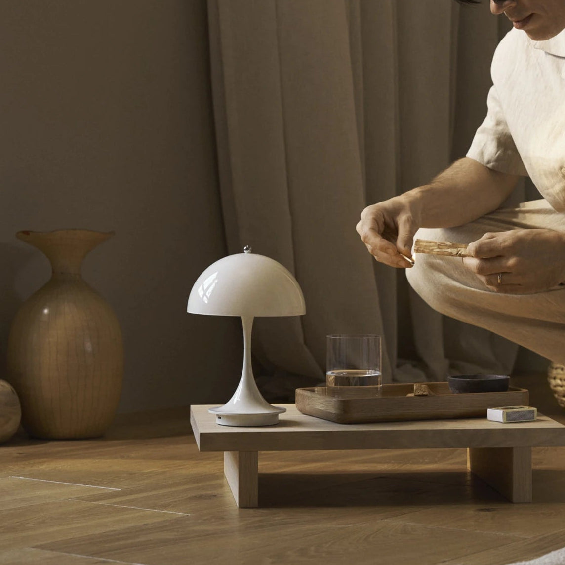 Lampe Lunéa allumée sur une table basse en bois