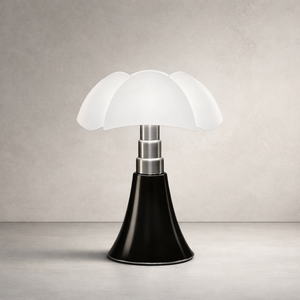 Lampe de table style champignon, abat-jour blanc à pétales, tige métal argent, base conique noire sur fond neutre.