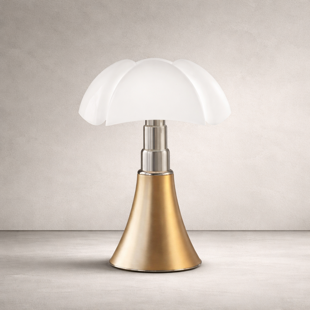 Lampe de table style champignon, abat-jour blanc à pétales, tige métal argent, base conique dorée sur fond neutre.