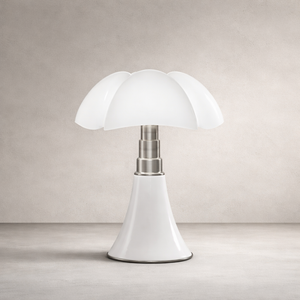 Lampe de table style champignon, abat-jour blanc à pétales, tige métal argent, base conique blanche sur fond neutre.