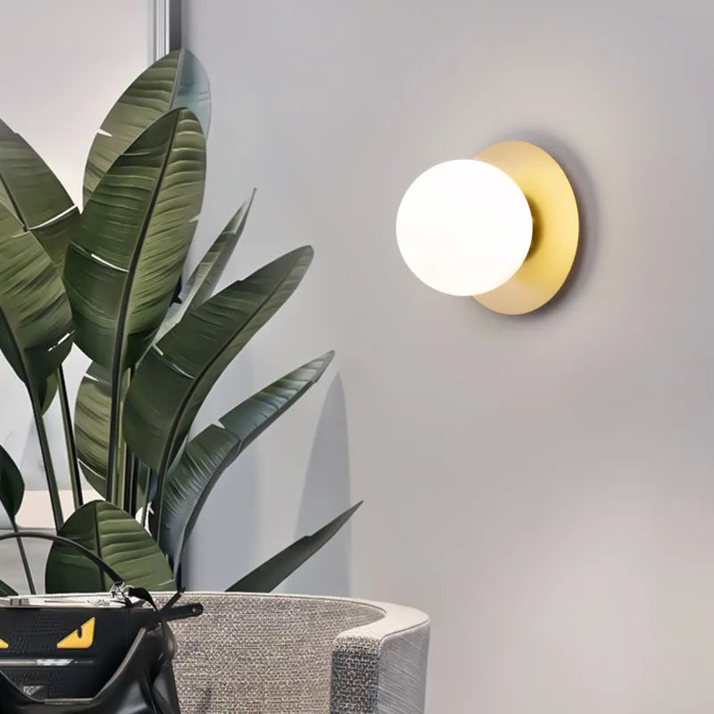 Applique Néveil dorée allumée près d'une plante