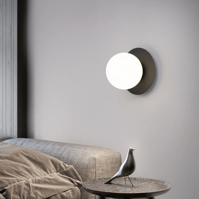 Applique Néveil noire allumée au-dessus d'un lit