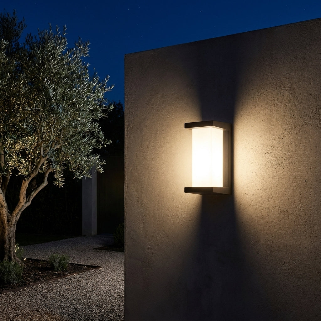 Applique murale extérieure noire Noctéa (format vertical) sur un mur de jardin la nuit, lumière chaude