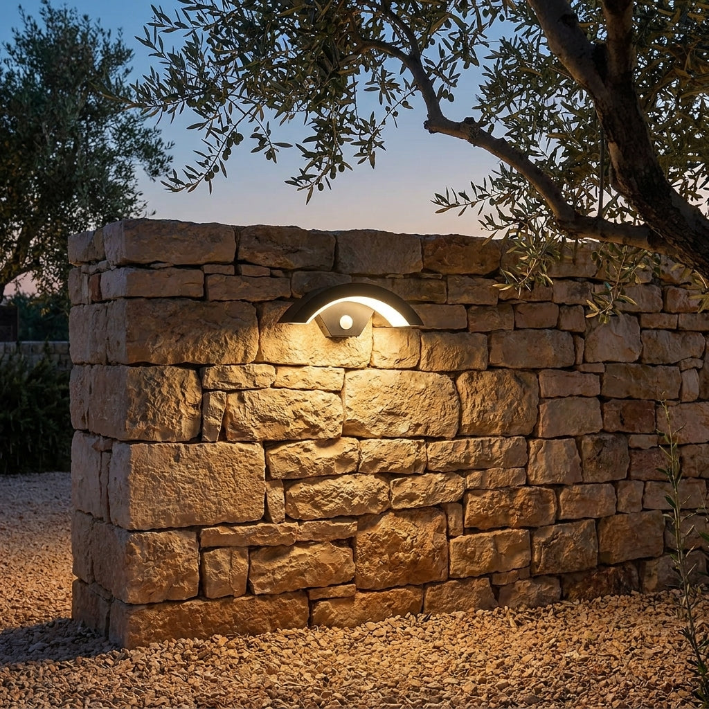 Applique extérieure Oculéil sur un mur en pierre dans un jardin méditerranéen