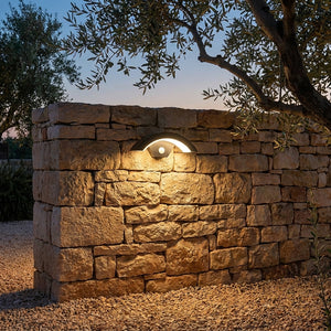 Applique extérieure Oculéil sur un mur en pierre dans un jardin méditerranéen