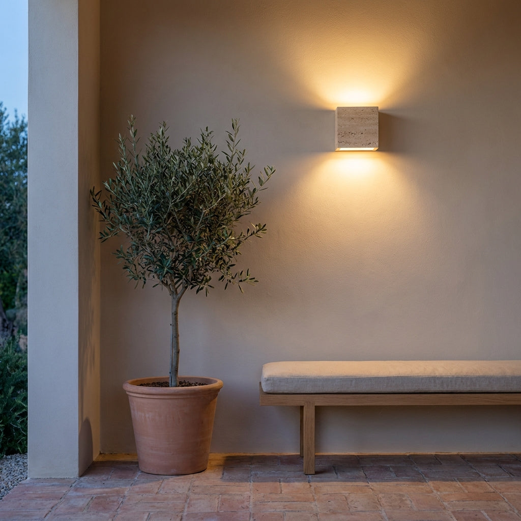 Applique murale cube en travertin Luminosa en extérieur abrité sur une terrasse couverte, lumière chaude au crépuscule