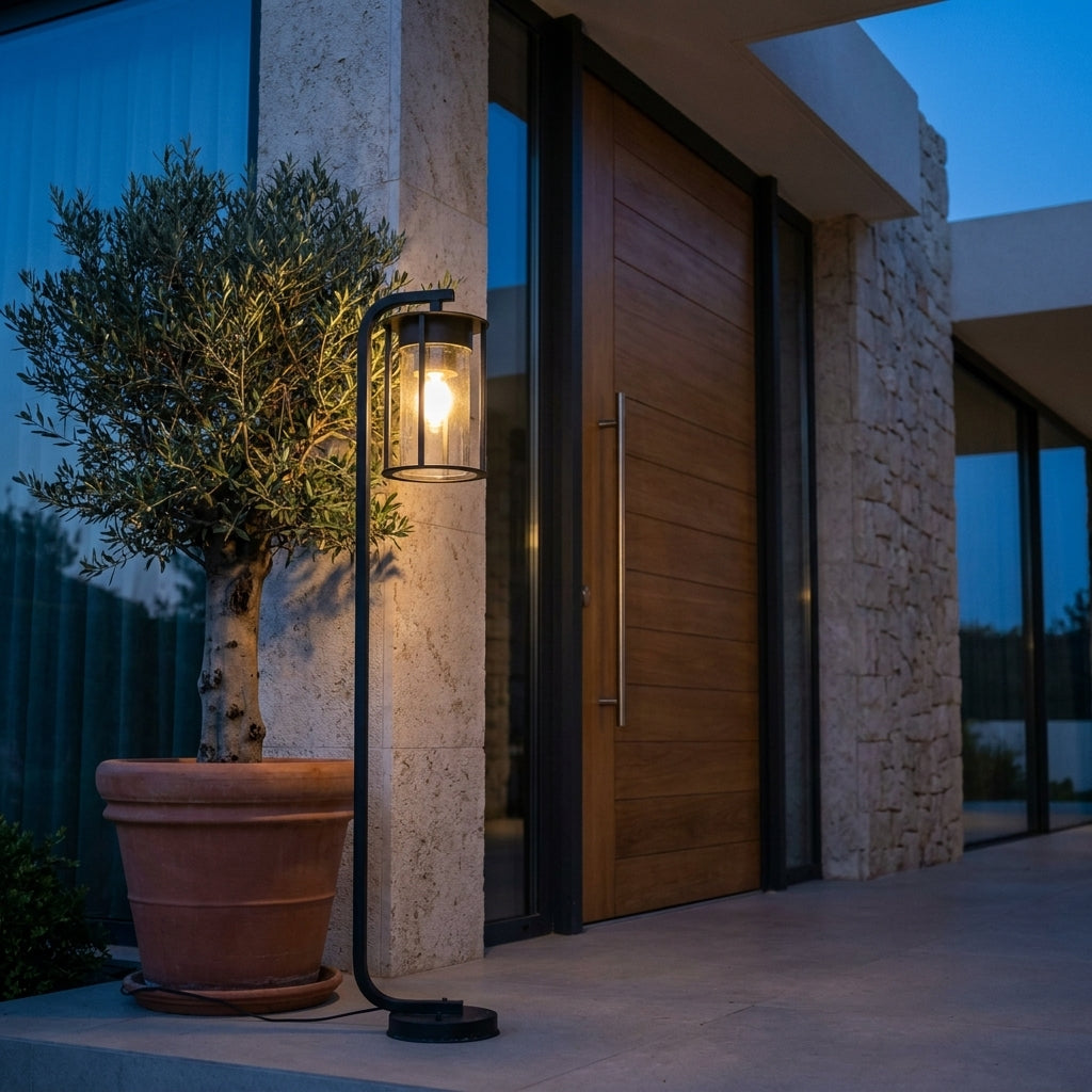 Lampadaire d'extérieur Vialis à côté d'une porte d'entrée en bois et d'un olivier en pot, lueur chaude
