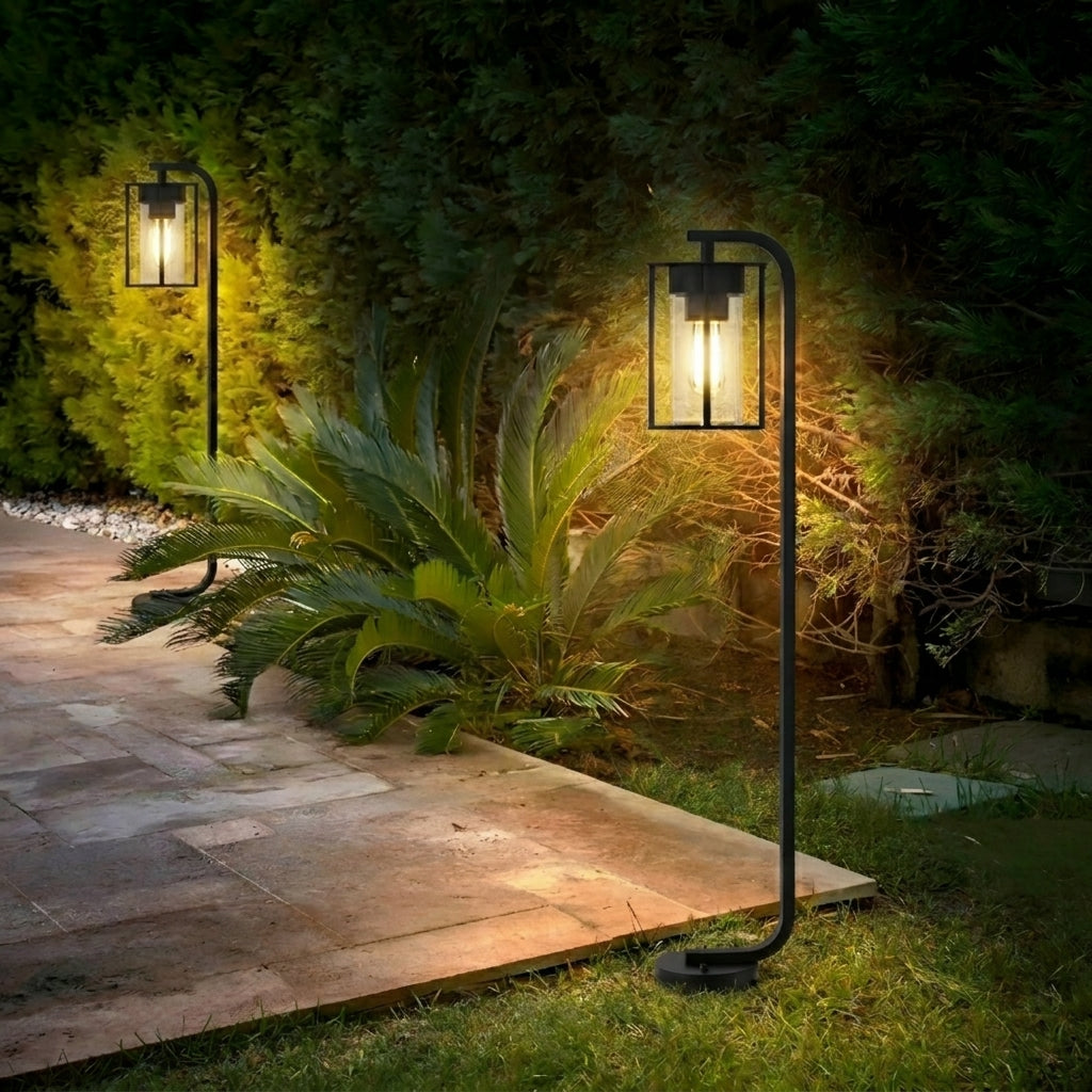 Lampadaires d'extérieur Vialis le long d'une allée pavée dans un jardin verdoyant la nuit