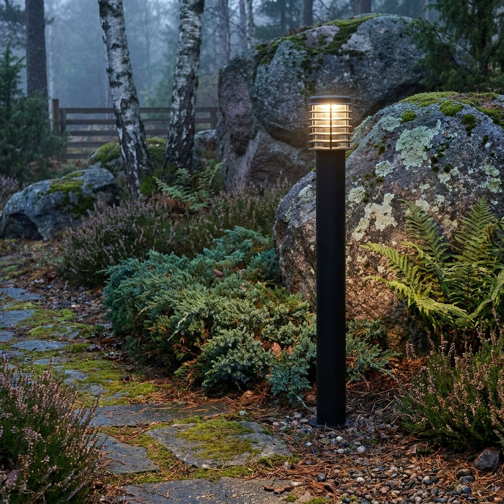 Lampadaire d'extérieur Noctis dans un jardin nordique parmi fougères et rochers moussus