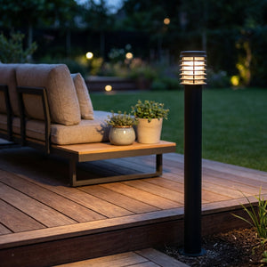Lampadaire d'extérieur Noctis au bord d'une terrasse en bois moderne, canapé lounge au crépuscule