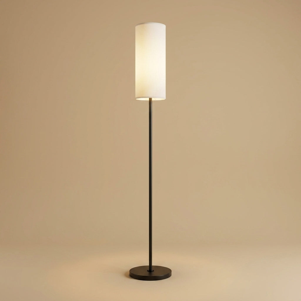 Lampadaire moderne Sereno : fût en métal noir et abat-jour cylindrique en tissu blanc, lumière blanc chaud, fond beige