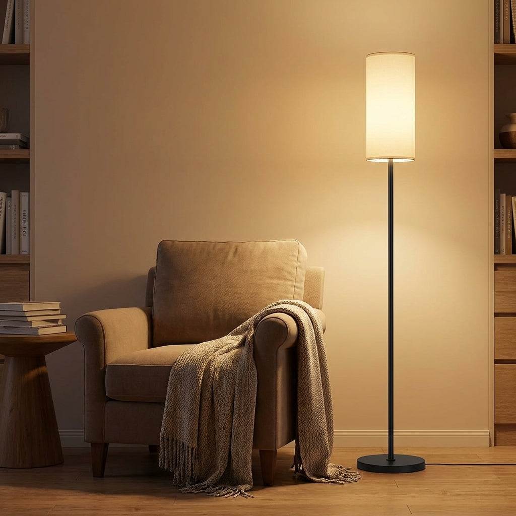 Lampadaire Sereno dans un coin lecture à côté d'un fauteuil avec plaid, lumière douce