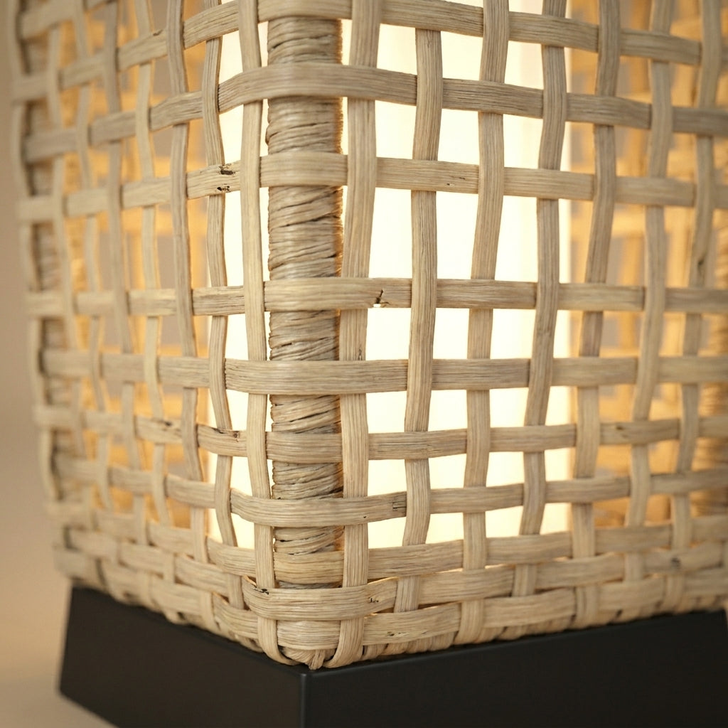 Détail du tressage en rotin ajouré du lampadaire solaire Soliro et de sa base noire, lumière chaude