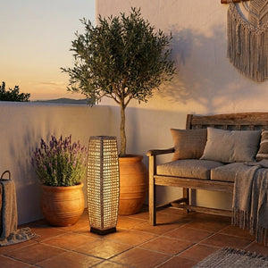 Lampadaire solaire Soliro en rotin sur une terrasse méditerranéenne avec olivier et lavande, lumière dorée