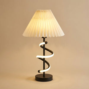 Lampe de table Hélia : abat-jour plissé crème et spirale LED autour d'un pied métal noir, sur fond beige