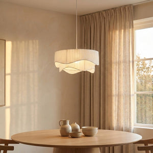 Suspension Ondora en tissu plissé au-dessus d'une table ronde en chêne clair, ambiance japandi